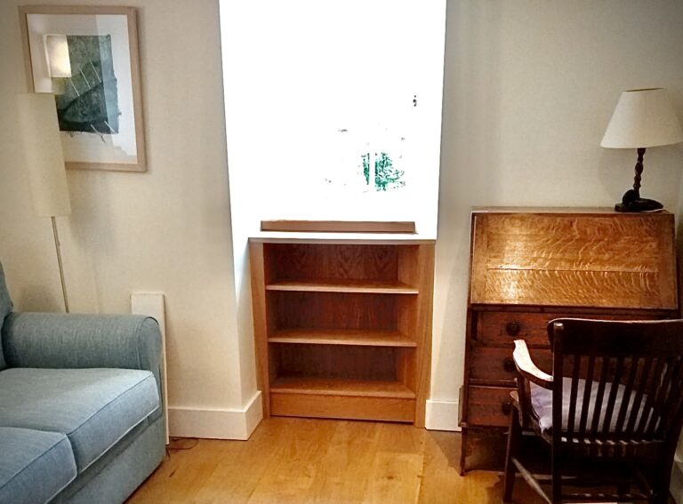 fitted oak bookcase with and irregular angled side and moveable shelves